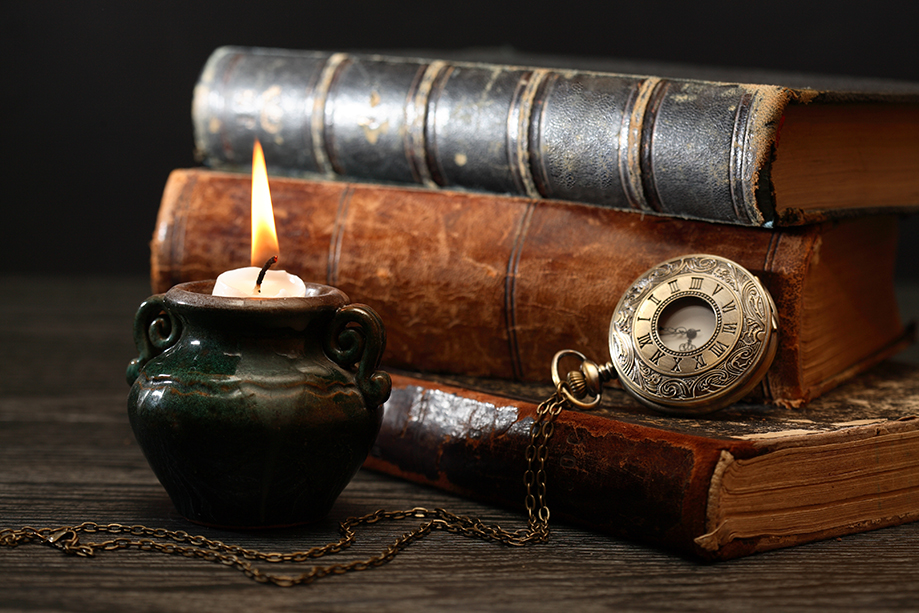 old books, candle and pocket watch