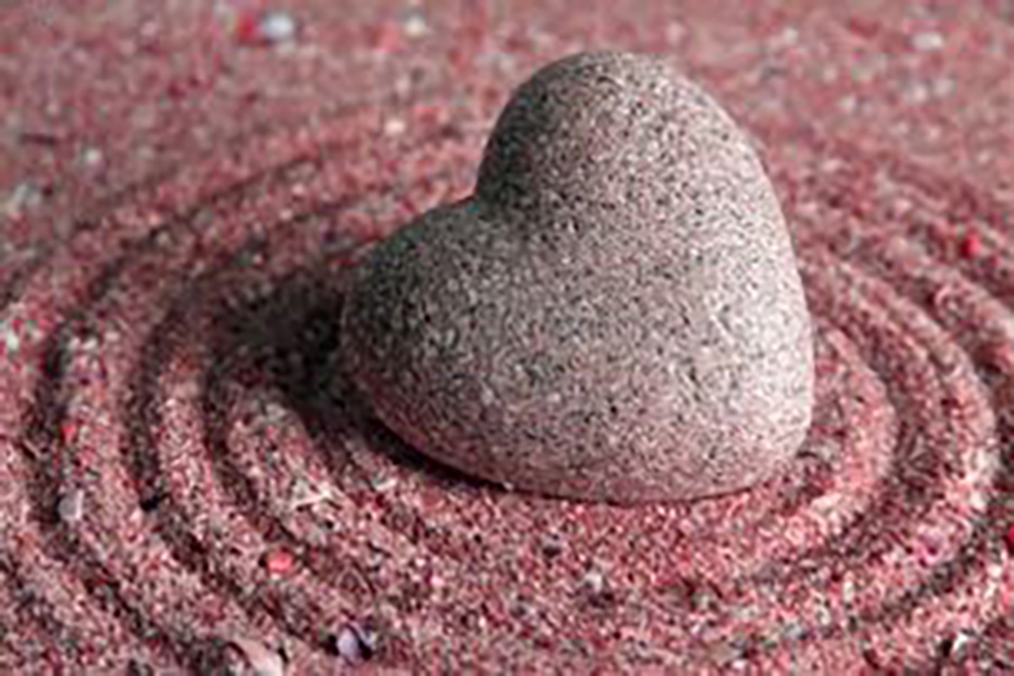 pink stone heart on sand