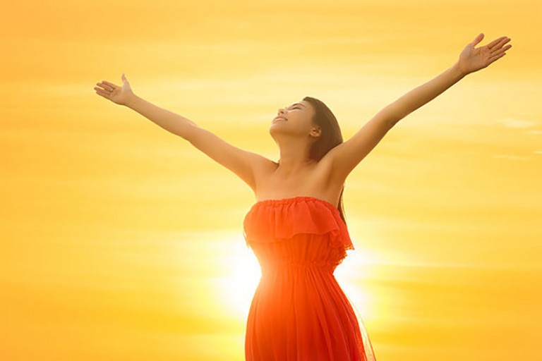 woman with open arms sunset