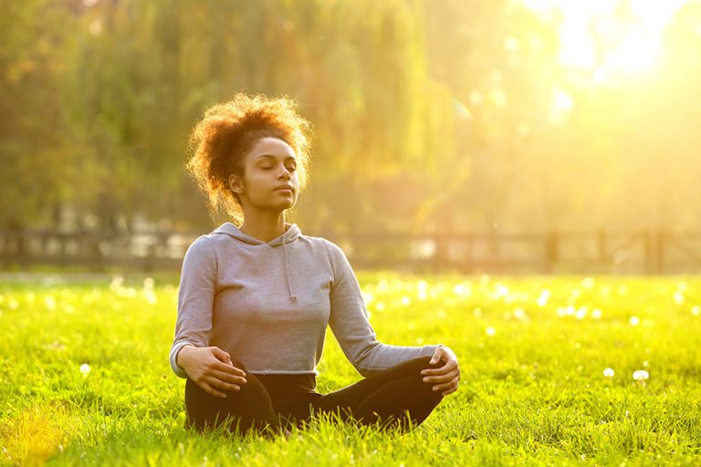 woman meditating under the sun