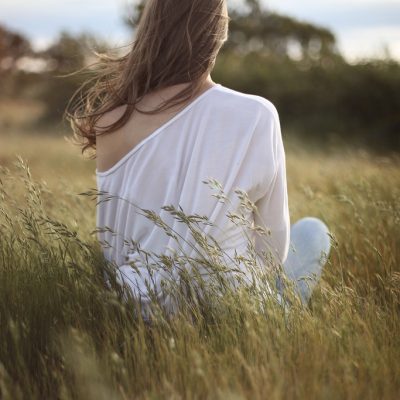 woman sitting down on a field