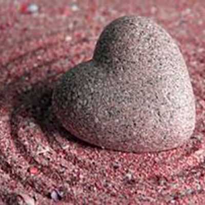 pink stone heart on sand