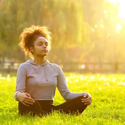woman meditating under the sun